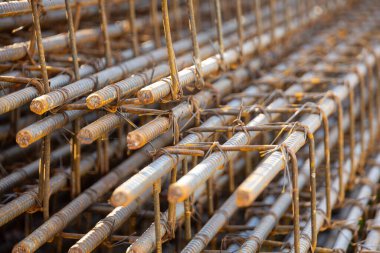 İnşaatta beton takviyesi için kullanılan çelik inşaat ızgarasına yakın çekim. Dayanıklılık için gerekli olan paslı çubuk deseni gösteriliyor.