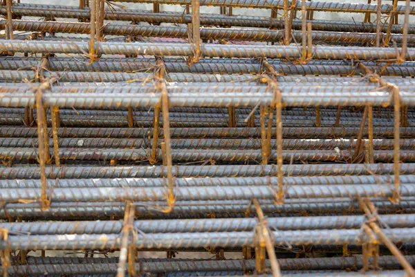 İnşaatta beton takviyesi için kullanılan çelik inşaat ızgarasına yakın çekim. Dayanıklılık için gerekli olan paslı çubuk deseni gösteriliyor.
