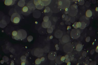 Koyu bir arkaplanda farklı boyut ve renklerde odaklanmış bokeh ışıkları.