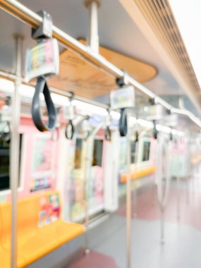 Parlak sarı koltukları ve paslanmaz çelik direkleriyle metro içi boş bir metro manzarası. Modern tren vagonu iyi ışıklandırılmış, üst kulpları ve pürüzsüz, temiz zeminleri var, hareket halindeki toplu taşımayı öneriyor..