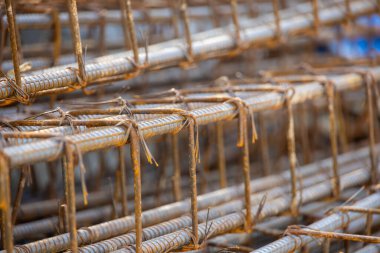 İnşaatta beton takviyesi için kullanılan çelik inşaat ızgarasına yakın çekim. Dayanıklılık için gerekli olan paslı çubuk deseni gösteriliyor.