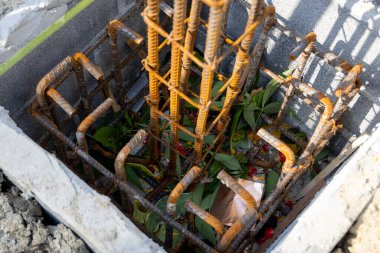 İnşaat için hazırlanmış çelik bir demir kafesi olan beton bir temele yakın çekim. İnşaat desteğinin ilk aşamasını gösterir