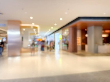 Hareketli bir alışveriş merkezinin bulanık görüntüsü modern bir perakende satış ortamının canlı atmosferini yakalıyor. İnsanlar alışveriş yaparken görülüyor.