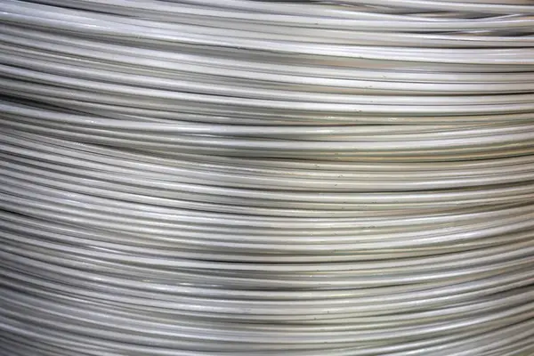 Pürüzsüz bir yüzeye sahip sarmal alüminyum kabloların yakın çekimi ve katmanlı örtüşen desen, yumuşak ışıklandırma.