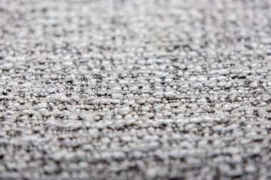 Açık gri ve koyu renkli ipliklerin karışımı sıkıca dokunmuş bir kumaşın yakın çekim görüntüsü ince desenli bir desen oluşturur..