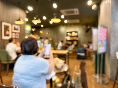 Müşterilerle dolu bir kafenin bulanık görüntüsü. Sosyal ortam için soyut ve atmosferik bir görünüm oluşturur