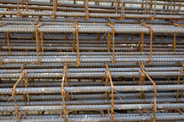İnşaatta beton takviyesi için kullanılan çelik inşaat ızgarasına yakın çekim. Dayanıklılık için gerekli olan paslı çubuk deseni gösteriliyor.