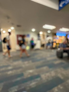 Havaalanının iç kısmının bulanık görüntüsü, hafif ışıklandırma, oturma alanları ve sakin, bastırılmış bir atmosferi var..