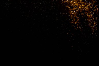 Soyut bulanık altın bokeh ışıkları koyu bir arkaplan karşısında dramatik ve şenlikli bir atmosfer yaratır.
