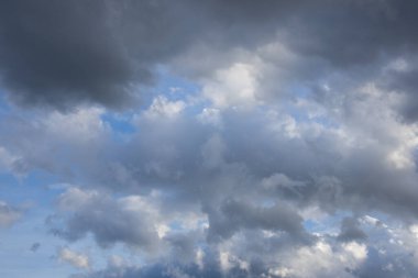 Gri ve koyu renkli bulutlarla dolu geniş bir gökyüzü görüntüsü yaklaşan bir fırtına ya da karamsar bir atmosferi işaret ediyor..