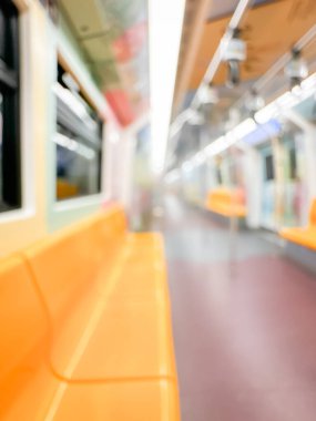 Parlak sarı koltukları ve paslanmaz çelik direkleriyle metro içi boş bir metro manzarası. Modern tren vagonu iyi ışıklandırılmış, üst kulpları ve pürüzsüz, temiz zeminleri var, hareket halindeki toplu taşımayı öneriyor..