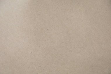 Kahverengi bir Kraft kağıt dokusunun yüksek çözünürlüklü yakın çekimi, doğal ve biraz pürüzlü bir yüzeyi var. Arkaplan olarak kullanmak için ideal