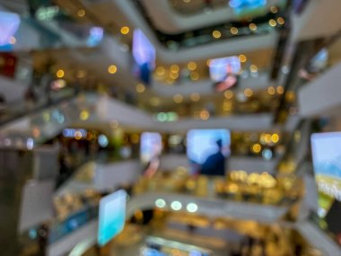 Hareketli bir alışveriş merkezinin bulanık görüntüsü modern bir perakende satış ortamının canlı atmosferini yakalıyor. İnsanlar alışveriş yaparken görülüyor.