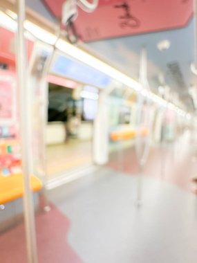Parlak sarı koltukları ve paslanmaz çelik direkleriyle metro içi boş bir metro manzarası. Modern tren vagonu iyi ışıklandırılmış, üst kulpları ve pürüzsüz, temiz zeminleri var, hareket halindeki toplu taşımayı öneriyor..
