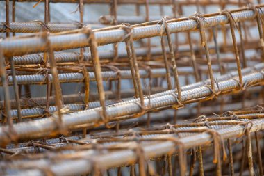 İnşaatta beton takviyesi için kullanılan çelik inşaat ızgarasına yakın çekim. Dayanıklılık için gerekli olan paslı çubuk deseni gösteriliyor.