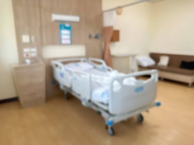 Lüks ve modern bir hasta odasındaki hastane yatağının bulanık görüntüsü. Atmosfer temiz ve etrafındaki manzarayı görebilirsiniz. Odanın etrafında pencereler var..