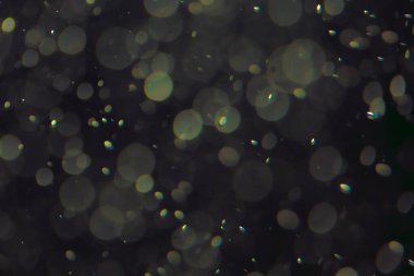 Koyu bir arkaplanda farklı boyut ve renklerde odaklanmış bokeh ışıkları.