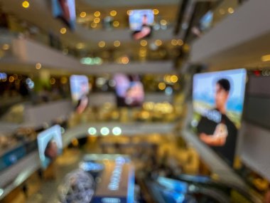 Hareketli bir alışveriş merkezinin bulanık görüntüsü modern bir perakende satış ortamının canlı atmosferini yakalıyor. İnsanlar alışveriş yaparken görülüyor.