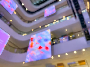 Hareketli bir alışveriş merkezinin bulanık görüntüsü modern bir perakende satış ortamının canlı atmosferini yakalıyor. İnsanlar alışveriş yaparken görülüyor.