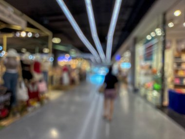 Hareketli bir alışveriş merkezinin bulanık görüntüsü modern bir perakende satış ortamının canlı atmosferini yakalıyor. İnsanlar yürürken, alışveriş yaparken ve eğlenirken görülürler.