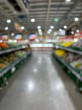 Raflarda çeşitli taze meyve ve sebzelerin sergilendiği bir market üretim bölümünün bulanık görüntüsü. Resim ürünün canlı renklerini ve dokularını yakalar