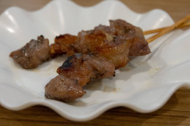 Üç ızgara domuz şiş yakın çekim hafif bir char ile, flüt beyaz tabak arka planda servis