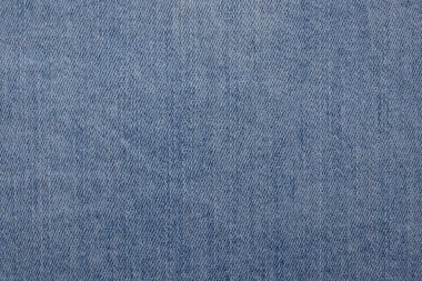 Görünür çapraz dokuması olan açık mavi bir kot kumaşın yakın çekimi. Doku tutarlı ve arka planlar için uygun..