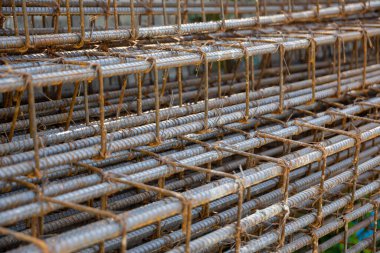 İnşaatta beton takviyesi için kullanılan çelik inşaat ızgarasına yakın çekim. Dayanıklılık için gerekli olan paslı çubuk deseni gösteriliyor.