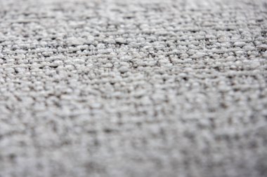 Açık gri ve koyu renkli ipliklerin karışımı sıkıca dokunmuş bir kumaşın yakın çekim görüntüsü ince desenli bir desen oluşturur..