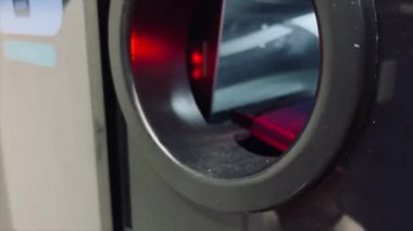 Bir kız geri dönüşüm makinesine plastik şişe yolluyor.