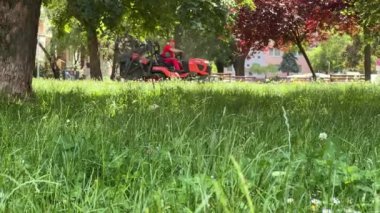 Çim biçme makineleriyle şehir parkındaki çimlerin bakımı