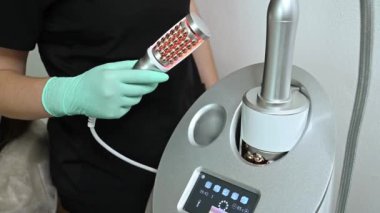 Bir profesyonel Endosphere cihazı uygular. Tıbbi ve kozmetik işlemlerde kullanılan gelişmiş bir lazer tedavi makinesini kullanan eldivenli bir elin yakın çekimi..