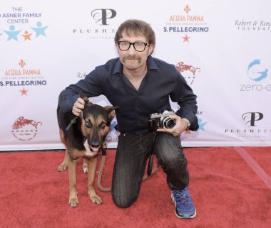 Studio City, CA - June 15, 2024: Alex Plank and his service dog attend the Ed Asner Celebrity Poker to Benefit Autism research.