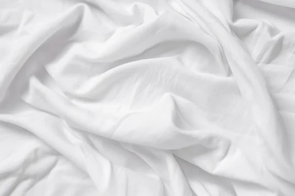 Closeup of rippled white silk fabric,white fabric draped in soft waves empty bed sheet