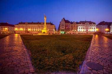 Union Meydanı ve Kutsal Üçlü Heykeli dramatik bir günbatımında görüldü. Fotoğraf: 19 Ağustos 2019 Timisoara, Timis County, Romanya.