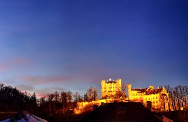 Meşhur Hohenschwangau Şatosu, Almanya 'nın ateşli gökyüzü ile geceleyin görüldü. Fotoğraf 25 Şubat 2019 'da çekildi..