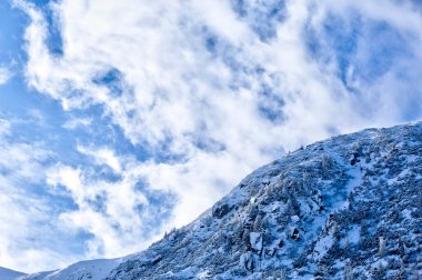 Karlı dağ manzarası ve Retezat dağlarında dramatik bulutlar. Fotoğraf 2 Şubat 2020 'de Romanya' nın Retezat Ulusal Parkı 'nda çekildi..
