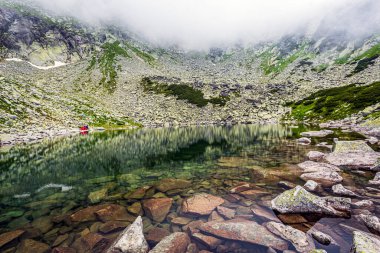 Retezat Dağları 'nda sisli bir yaz gününde güzel buzul Stevia Gölü. Fotoğraf 12 Temmuz 2020 'de Romanya' nın Karphatian Retezat Dağları 'nda bir yürüyüş sırasında çekildi..