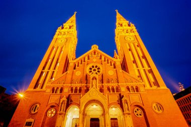 Szeged 'deki adak kilisesi ve kubbe meydanı, mavi saatte. Fotoğraf 29 Şubat 2020 'de Macaristan' ın Szeged kentinde çekildi..