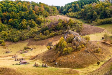 Fundatura Ponorului 'deki uzak bir dağ köyüne bakan kurt kayasının sonbahar manzarası. Fotoğraf 5 Ekim 2019 'da Romanya' nın Hunedoara eyaletinin Fundatura Ponorului kentinde çekildi..