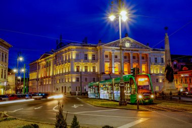 Arka planda Ioan Slavici Tiyatrosu ile mavi saatte Arad şehri manzarası. Fotoğraf 1 Mart 2020 'de Romanya' nın Arad kentinde çekildi..
