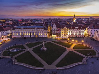 Union Meydanı hava manzarası. Etrafı barok tarzı binalar ve yakıcı günbatımı gökyüzü ile çevrili. Fotoğraf 6 Ocak 2023 'te Timisoara, 2023 Avrupa Kültür Başkenti, Timis County, Romanya' da çekildi..