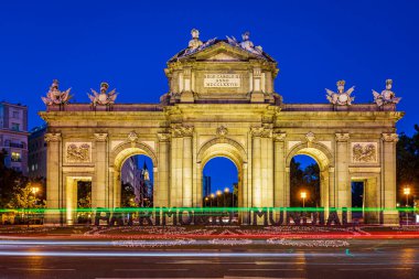Mavi saatte trafik ışıkları olan Alcala kapısı. Fotoğraf 31 Mayıs 2022 'de Madrid, İspanya' da çekildi..