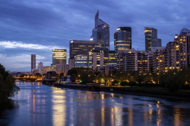 La Defence gökdelenleri Seine nehrinin mavi saatinde. Fotoğraf 23 Nisan 2022 'de Seine, Paris, Fransa üzerindeki bir köprüden çekildi..