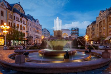 Mavi saatte Fıskiyeli Zafer Meydanı. Fotoğraf 18 Nisan 2023 'te Avrupa Kültür Başkenti Timisoara, Timis, Romanya' da çekildi..