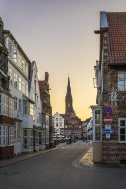 Arka planda St. Nicolai kilisesinin ana kulesi olan Luneburg sokaklarında. Fotoğraf 5 Haziran 2023 'te Luneburg' da veya Hanseatic City of Luneburg, Almanya 'da çekildi..