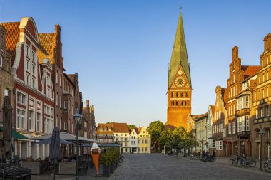Luneburg sokaklarında, arka planda St. John kilisesinin hafifçe eğilmiş kulesi var. Fotoğraf 5 Haziran 2023 'te Luneburg' da veya Hanseatic City of Luneburg, Almanya 'da çekildi..