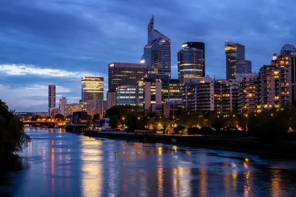 La Defence gökdelenleri Seine nehrinin mavi saatinde. Fotoğraf 23 Nisan 2022 'de Seine, Paris, Fransa üzerindeki bir köprüden çekildi..