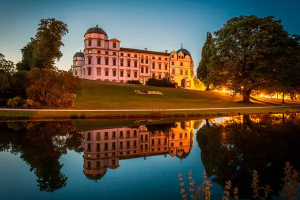 Celle Castle 'ın ve çevresindeki bahçelerin görüntüsü suya yansıdı. Fotoğraf 4 Haziran 2023 'te Celle, Aşağı Saksonya, Almanya' da çekildi..