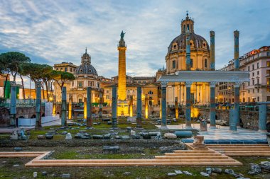 İmparator Trajan 'ın oturum ve sütununda akşam vakti. Arka planda Loreto 'lu Santa Maria' nın aydınlatılmış kilisesi duruyor. Fotoğraf 12 Şubat 2025 'te İtalya' nın Lazio bölgesinde çekildi..